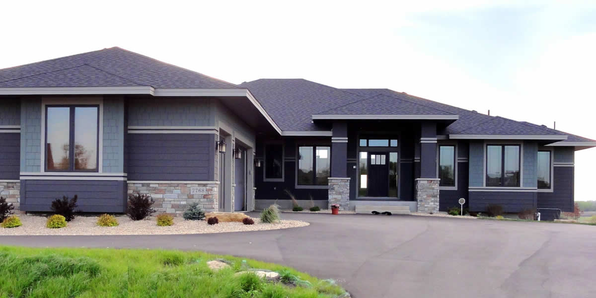 Home with siding, roofing, windows, soffit, facia, trim, and stone work