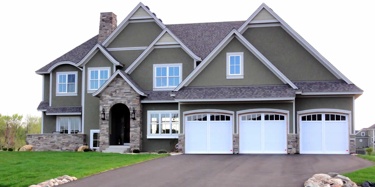 Home with siding, roofing, windows, soffit, facia, trim, and stone work