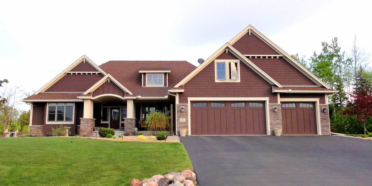 Home with siding, roofing, windows, soffit, facia, trim, and stone work