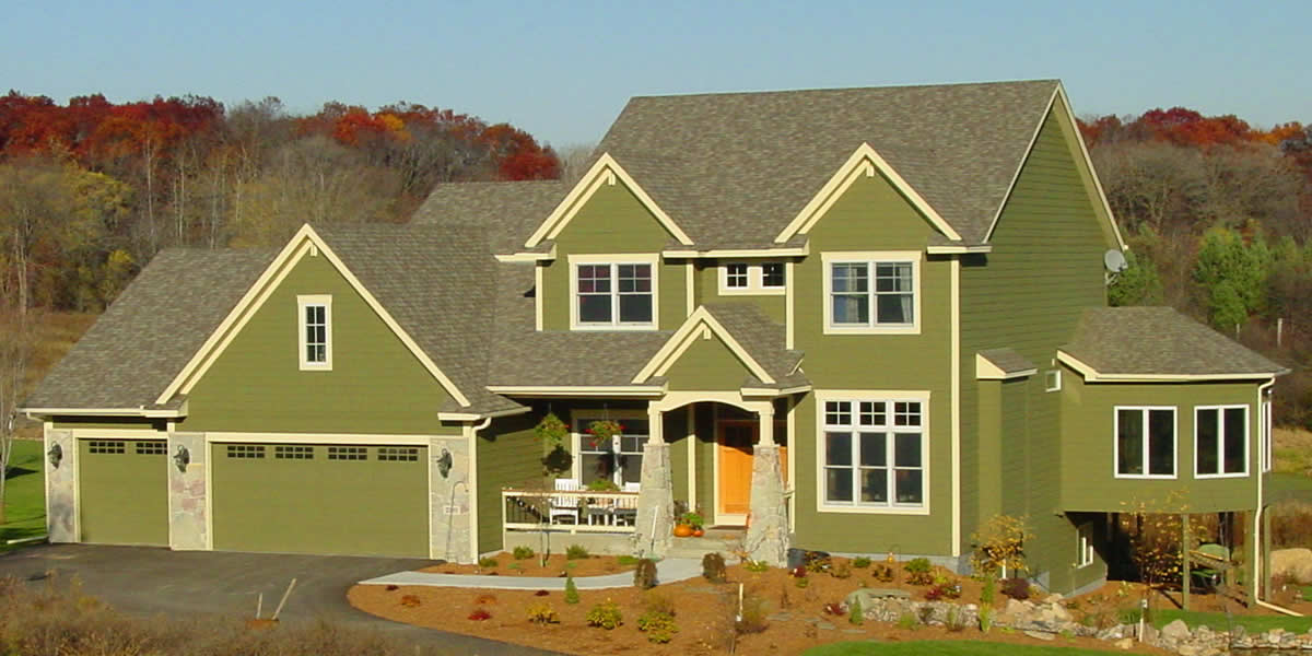 Home with siding, roofing, windows, soffit, facia, trim, and stone work